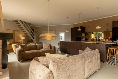Modern open-plan living room and kitchen at Sea'Ya Casa Pavão villa in Colares with brown sofas, pendant lighting, and dark