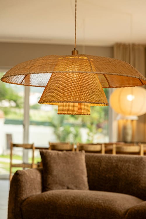 Woven pendant lamp hanging above brown sofa in Sea'Ya Casa Pavão villa living room with garden views