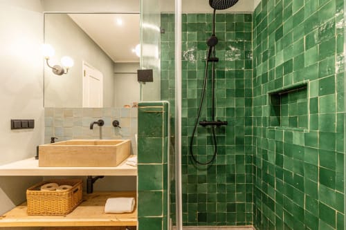Modern bathroom at Sea'Ya Casa Pavão villa with wooden sink, green tile shower, and black fixtures