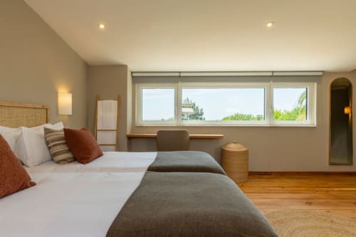Spacious modern bedroom at Sea'Ya Casa Pavão villa in Colares with twin beds, garden views, desk, and wooden flooring