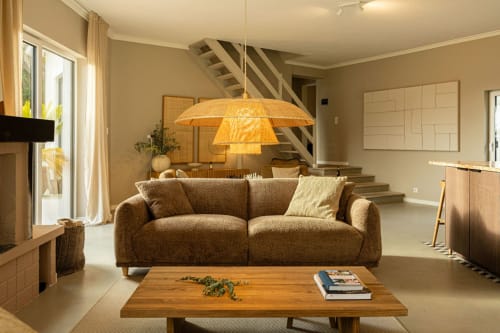 Spacious living room at Sea'Ya Casa Pavão villa in Colares with beige sofa, wooden table, and designer pendant lamp