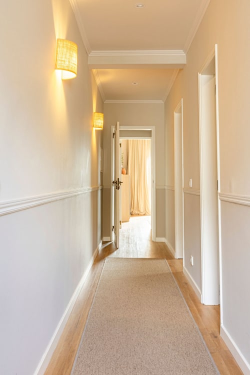 Elegant hallway at Sea'Ya Casa Pavão villa in Colares with white walls, warm lighting, wooden floors, and doors leading to