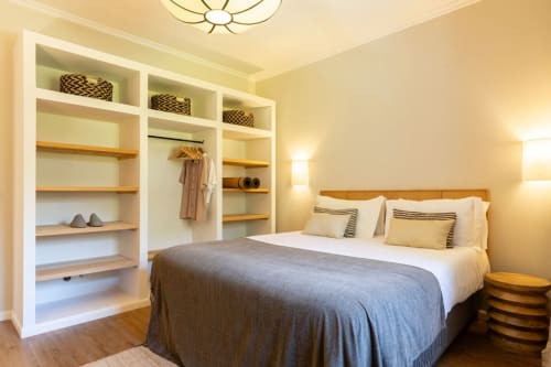 Bright bedroom at Sea'Ya Casa Pavão villa in Colares with queen bed, white built-in shelving, wooden accents, and warm