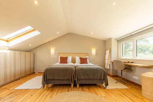 Spacious attic bedroom at Sea'Ya Casa Pavão villa in Colares with twin beds, wooden beams, skylight, and garden views