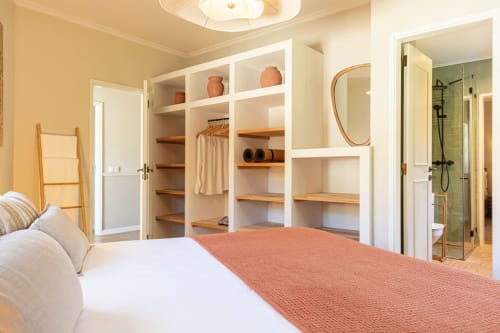 Spacious master bedroom at Sea'Ya Casa Pavão villa in Colares with built-in wardrobe, ensuite bathroom, and modern amenities