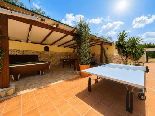 Spacious outdoor entertainment area at Casa Emilia villa in Moraira with ping pong table, billiards, and shaded terrace