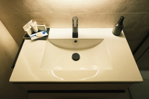 Moderno lavamanos blanco con artículos de tocador en el apartamento Casa Grande de Covas en Taboada, Lugo