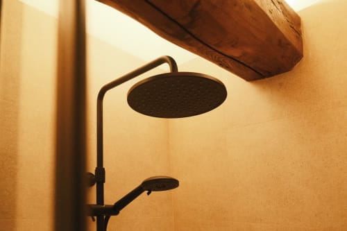 Moderno cabezal de lluvia negro con ducha de mano en baño alicatado de Casa Grande de Covas, apartamento rural en Taboada, Lugo