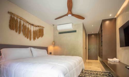 Habitación moderna en Zen Stays Tulum con ventilador de madera, ropa de cama blanca y decoración minimalista
