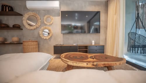 Luxe bathroom at Zen Stays Tulum with soaking tub, wooden tree-stump table, and coastal decor