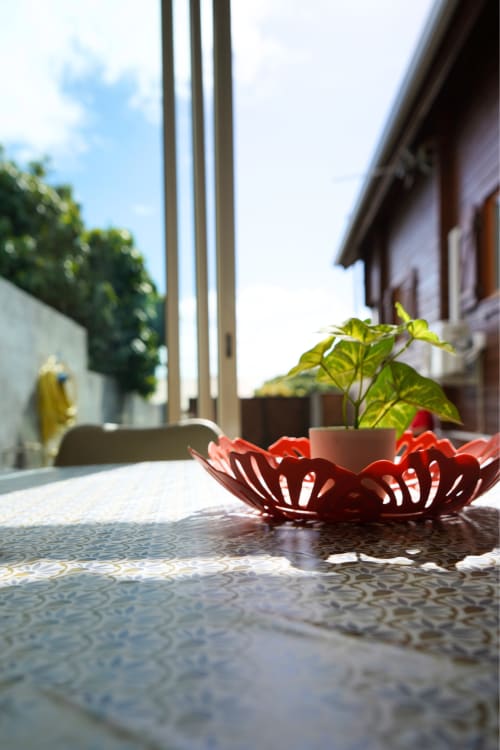 Bol décoratif rouge avec plante sur la table de la terrasse du bungalow R'marine439 à Sainte-Rose, île de la Réunion