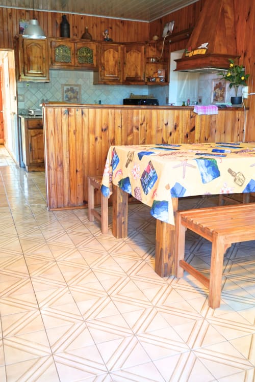 Coin repas du gîte en bois avec cuisine à R'marine439 BnB à Sainte-Rose, mobilier bois et carrelage géométrique