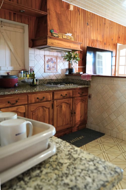 Cuisine en bois avec plan de travail en granit et cuisinière à gaz du gîte R'marine439 Caz' mangoustan à Sainte-Rose