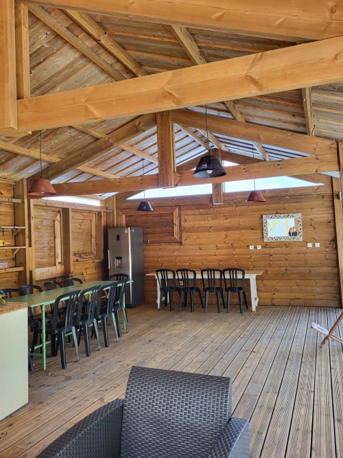 Spacieuse villa avec salle à manger et salon, poutres en bois, tables multiples, électroménagers inox et puits de lumière