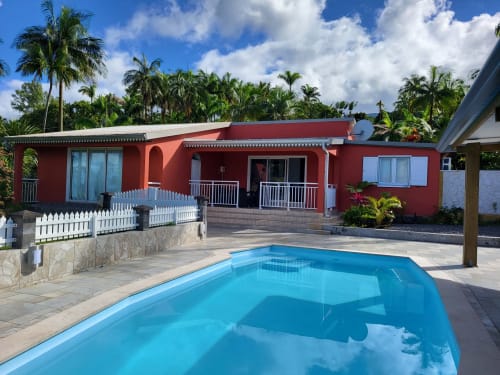 Villa tropicale aux façades rouges, piscine, palmiers et vue mer à Sainte-Rose, La Réunion