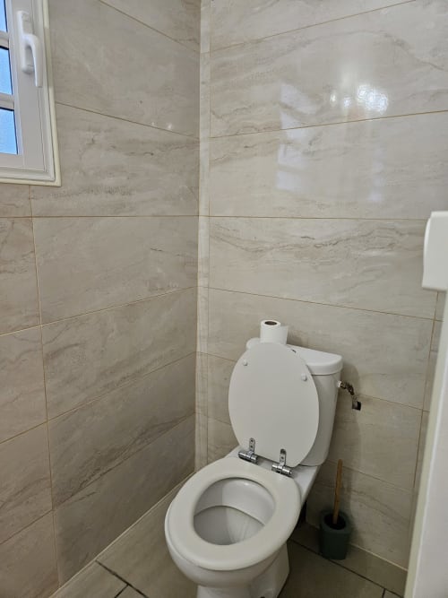 Salle de bain moderne de la Villa Cœur des laves au gîte R'marine439 à Sainte-Rose, avec carrelage marbre et toilettes