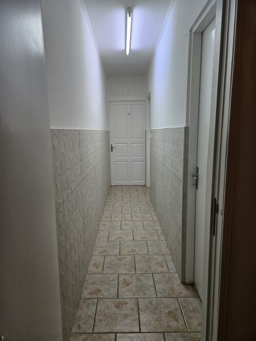 Couloir moderne aux murs texturés en bas et blancs en haut de la villa R'marine439 à Sainte Rose, Réunion