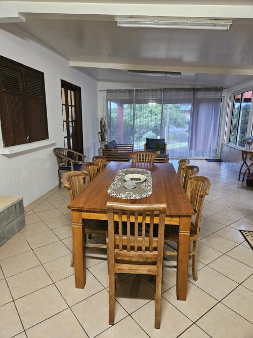 Spacieux espace de repas à la Villa Cœur des laves chez R'marine439 avec table en bois, vue sur la mer et équipements modernes