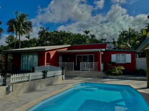 Villa rouge avec piscine à la R'marine439 BnB à Sainte-Rose, Réunion, avec balustrades blanches et palmiers