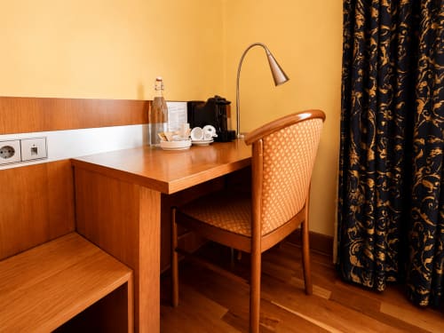 Hotel De La Poste standard room in Esch-sur-Alzette with wooden desk, chair, and work lamp