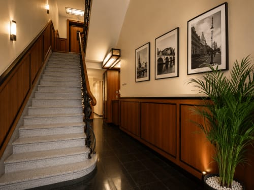 Escalier élégant de l'Hôtel De La Poste à Esch-sur-Alzette avec rampes en bois, photographies encadrées de la ville et design moderne