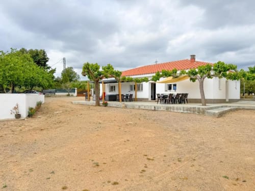 Modern villa in Reus with terracotta roof, white walls, outdoor dining area, private patio, and garden views surrounded by