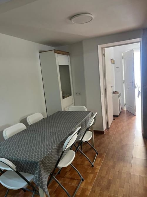 Dining area in Rentalaya villa in Reus with table, chairs, mirror, and access to kitchen and hallway