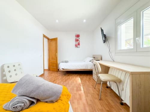 Bright villa bedroom in Reus with twin beds, wooden desk, terrace views, and modern amenities