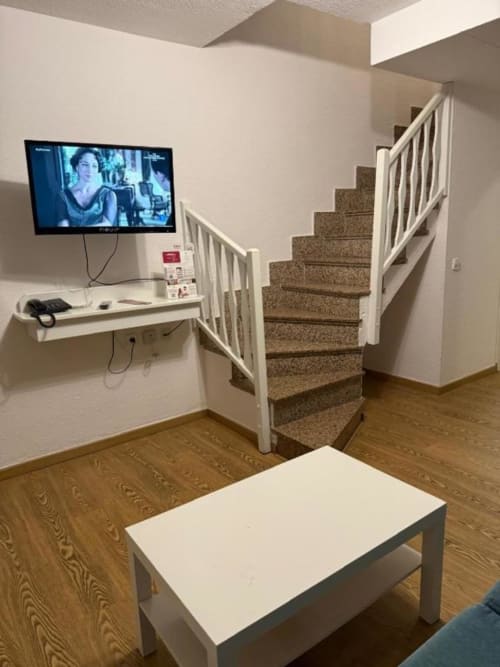 Living room of Rentalaya 2-bedroom apartment in Peñíscola with stairs, flat-screen TV, and wooden floors