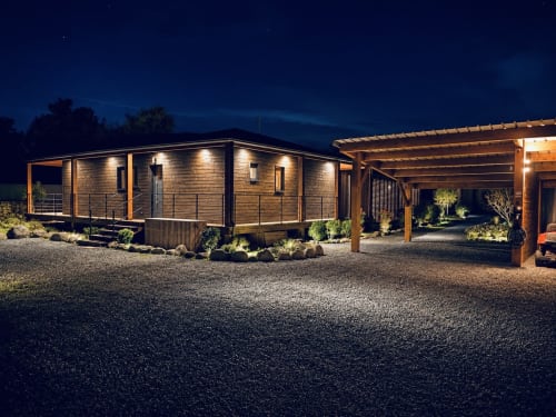 Villa moderne aux Villas Vallée d'Asco en Corse, illuminée la nuit avec façade bois, terrasse et jardins aménagés