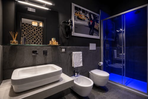 Bagno moderno presso B&B Pellicano Guest House a Reggio Calabria con vasca bianca, WC, bidet e doccia in vetro blu