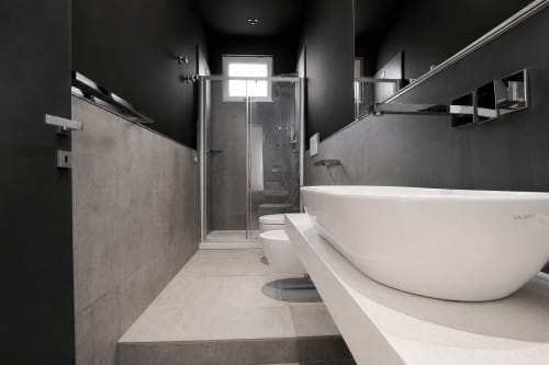 Moderna suite da bagno presso la Guest House B&B Pellicano a Reggio Calabria con vasca freestanding, doccia in vetro e pareti