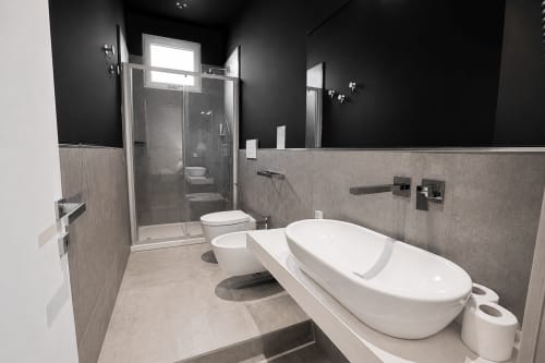 Bagno moderno nella suite della Guest House B&B Pellicano con vasca freestanding, box doccia e doppio lavabo a Reggio Calabria