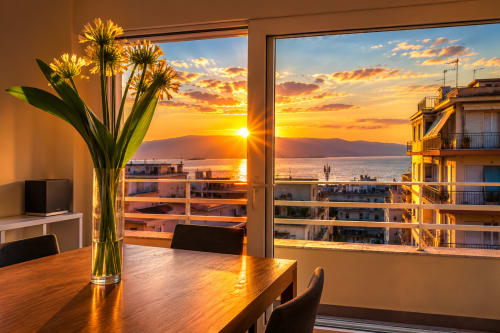Tramonto sul mare visto dall'Attico con Vista Mare del B&B Pellicano a Reggio Calabria con fiori sul tavolo