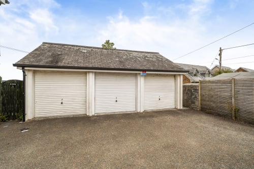 Triple garage with white roller doors and slate roof at Sunflower Cottage, Exeter holiday property