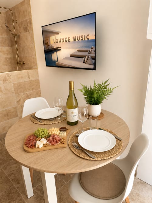 Ambiance élégante à l'hôtel L'Escapade avec vin, plateau de charcuterie et musique d'ambiance
