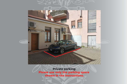 Parcheggio privato del The Kraken Inn, Bergamo. Auto nera in cortile pavimentato con delimitazione rossa.
