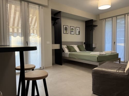 Camera da letto moderna a La Casetta dei Ronchi a Marina di Massa con biancheria verde, balconi vista mare e design contemporaneo