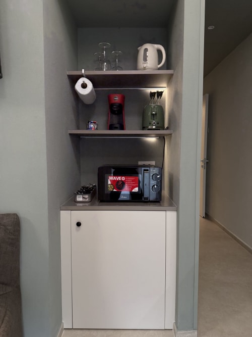 Angolo cucina moderno con mobile bianco, ripiani con bollitore, caffettiera, tostapane e utensili da cucina a La Casetta dei