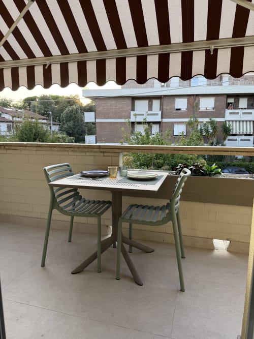 Allestimento per cena in balcone a La Casetta dei Ronchi con tavolo, sedie e vista sul mare di Marina di Massa