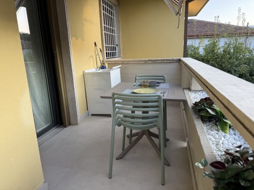 Sedia verde al tavolo sul balcone soleggiato con vista mare, appartamento La Casetta dei Ronchi, Marina di Massa