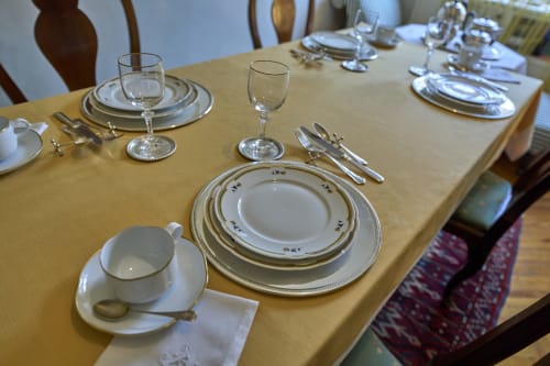 Elegant formal dining table setting at A Casa Armenia B&B in Turin with layered plates, silverware, and crystal glassware