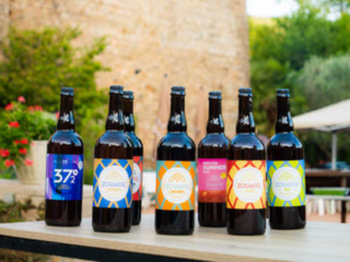 Bières artisanales exposées aux Gites Les Muriers, une maison d'hôtes française à Bourgvilain avec des bouteilles colorées