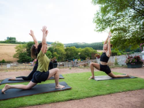 Cours de yoga en plein air sur la pelouse des Gîtes Les Muriers à Bourgvilain, avec vue sur la campagne