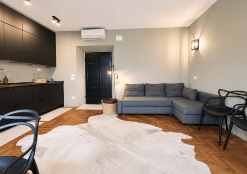 Modern apartment with gray sofa, black kitchen, wooden floors and air conditioning at Tuscan Townhouse, Montemassi