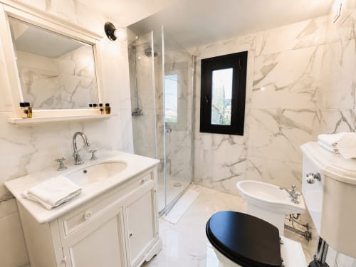 Elegant marble bathroom in Garden Suite at Tuscan Townhouse with rainfall shower and modern fixtures