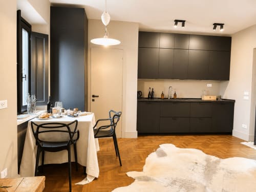 Modern kitchen and dining area in Garden Suite apartment at Tuscan Townhouse with black cabinetry and wood floors