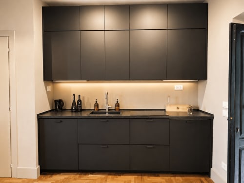 Modern black kitchen with sink and wine bottles in Garden Suite at Tuscan Townhouse, Montemassi