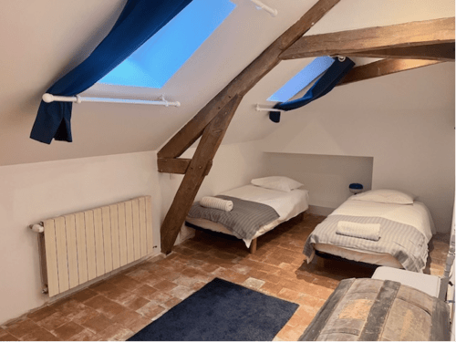 Chambre twin confortable au Château de Moulins avec poutres apparentes, puits de lumière et salle de bain partagée