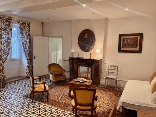 Chambre élégante du Château de Moulins avec mobilier d'époque, cheminée et fauteuils dorés